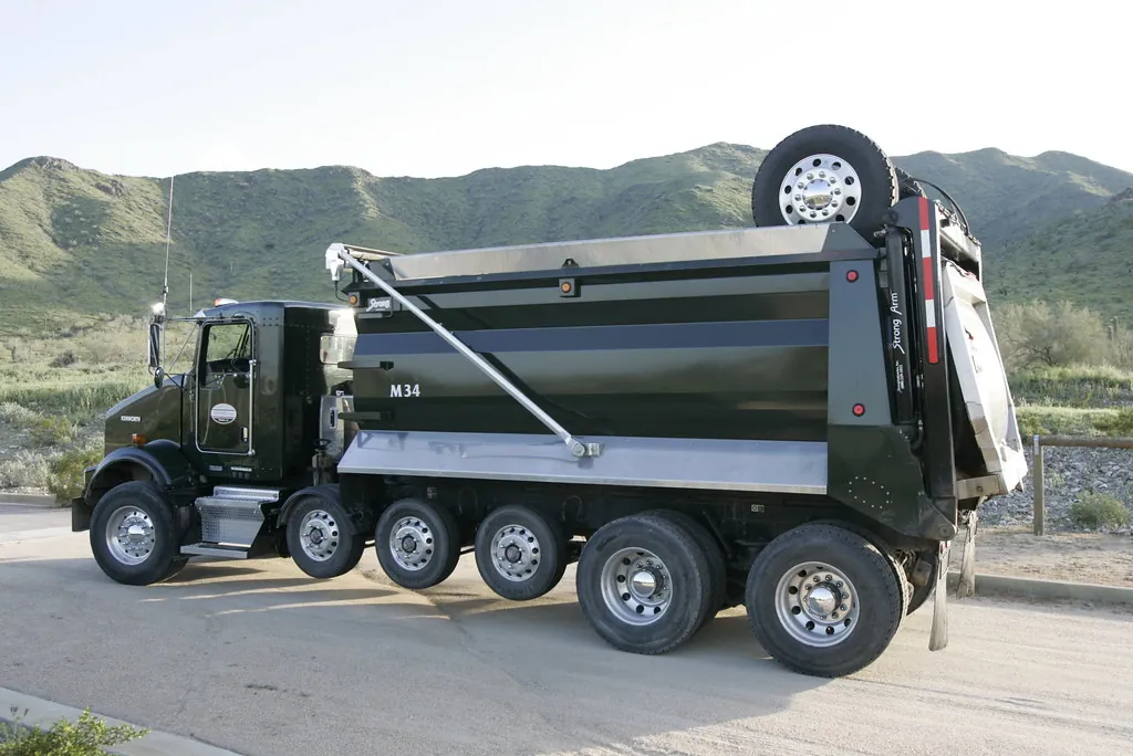 Black dump truck with strong arm tarp system
